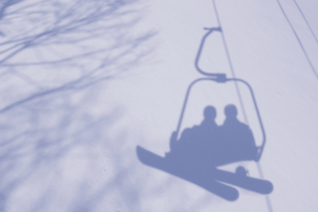 雪に映るリフトに乗っているカップルのシルエット