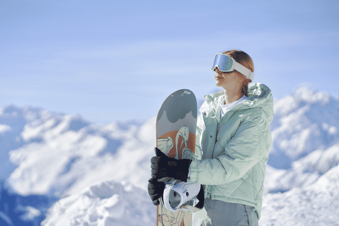 スノボを抱えて空を見上げる女性
