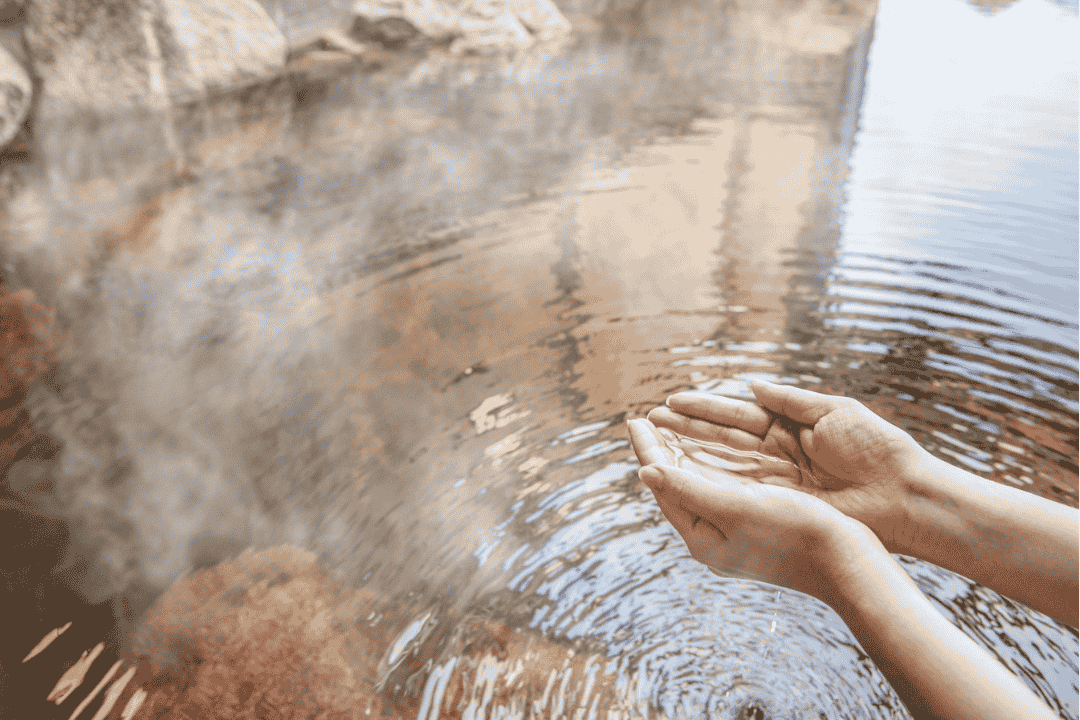 温泉のお湯を手でくべる姿