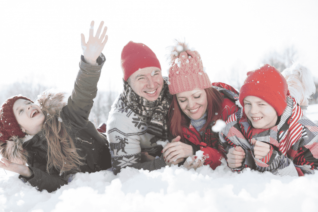 雪に寝そべる家族